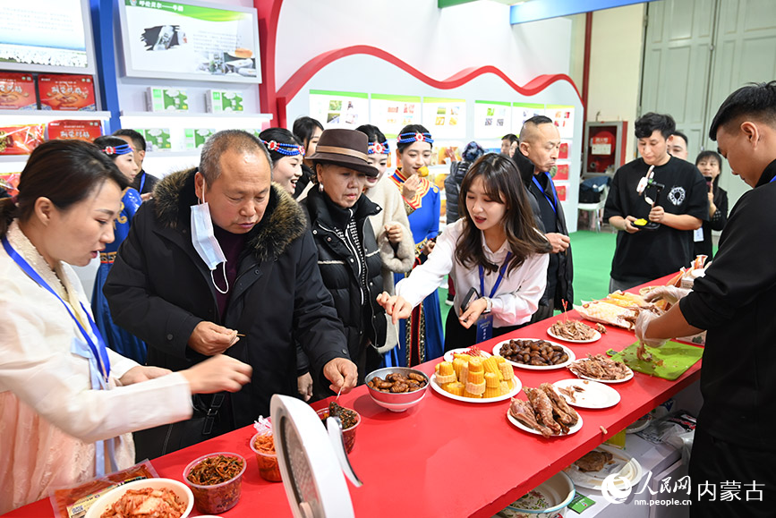 阿荣旗展区内，游客正在试吃特色食品。人民网记者 刘艺琳摄