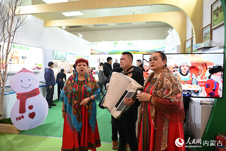 额尔古纳展区外，俄罗斯族工作人员正在表演。人民网记者 刘艺琳摄