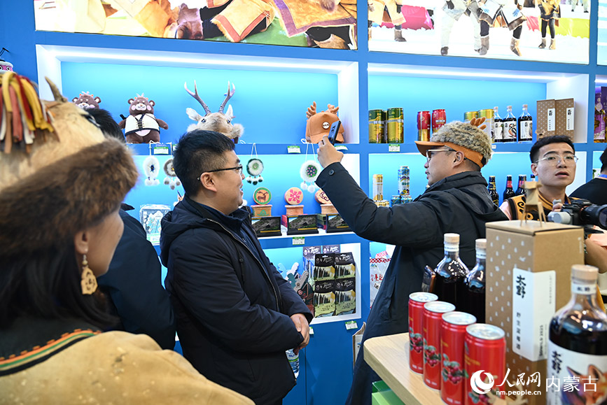 鄂伦春展区内，游客正在试戴帽子。人民网记者 刘艺琳摄