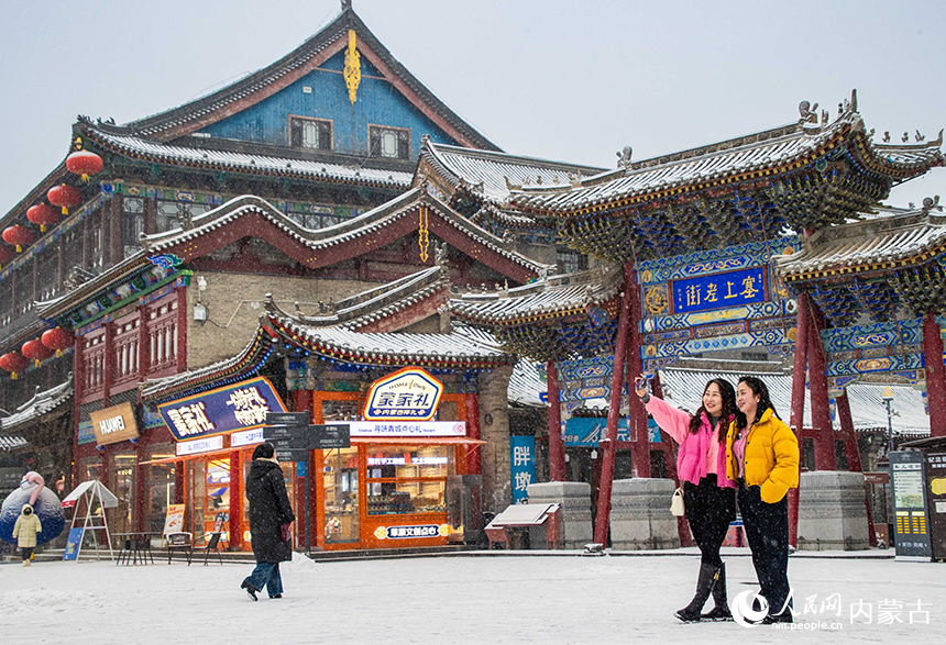 游人在呼和浩特市玉泉區塞上老街旅游休閑街區賞雪拍照。丁根厚攝