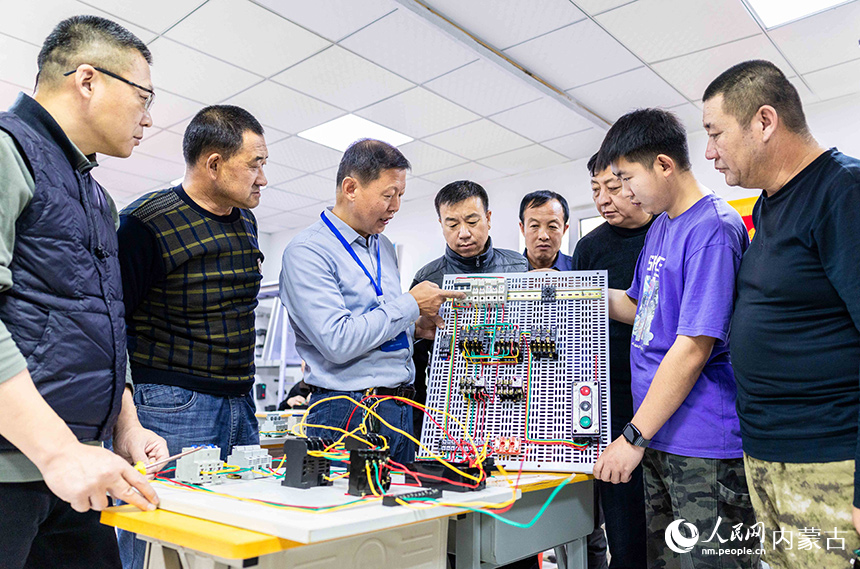 培训班讲师（左三）在呼和浩特市玉泉区电工职业技能培训班上为学员讲解电路原理相关知识。丁根厚摄