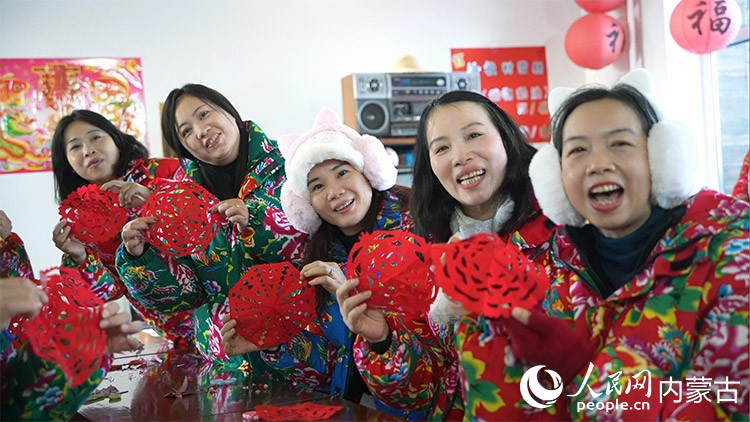 来自广东虎门的游客体验冷极村“剪窗花”制作项目，图为游客向记者展示剪好的窗花。人民网记者 张力洋摄