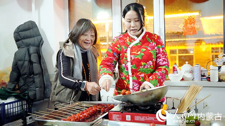 来自香港的游客体验蘸糖葫芦过程。人民网记者 张力洋摄