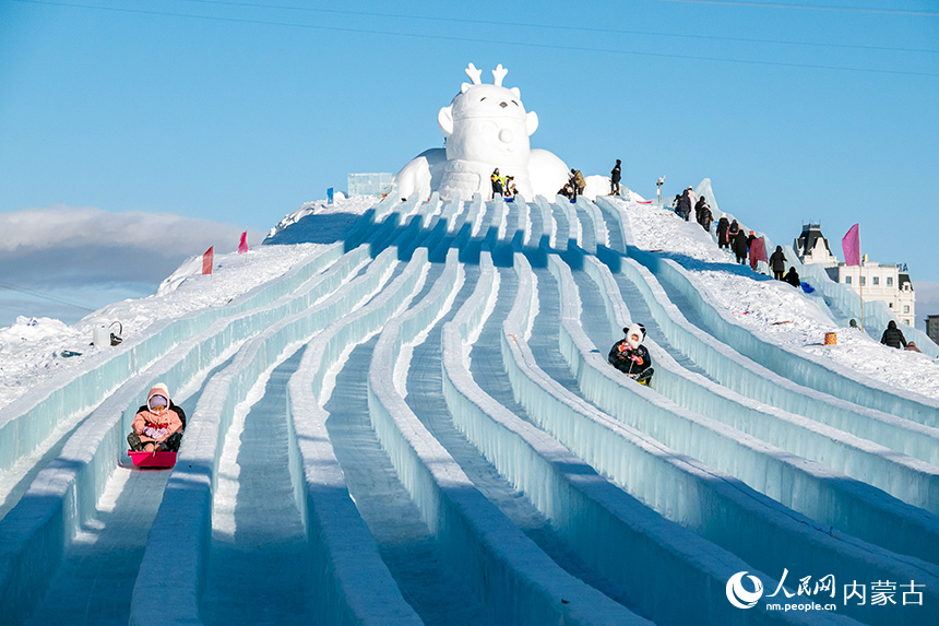 孩子们在冰雪那达慕上体验滑冰梯。吕昊俊摄