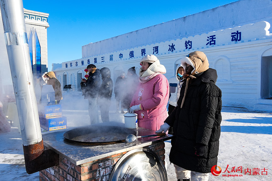 工作人员现场烹制小鸡炖蘑菇，香气随热气升腾，成为冰天雪地里一抹诱人的烟火气息。实习生 牛佳摄
