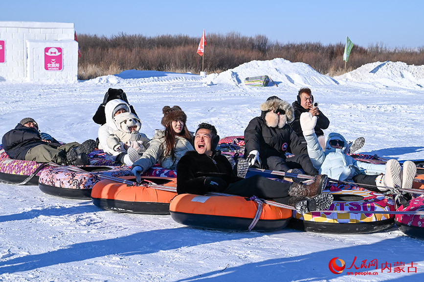 拖拉机拉雪圈项目引来阵阵欢笑，游客们在雪地上畅快滑行，体验纯真冰雪乐趣。实习生 刘迎雪摄