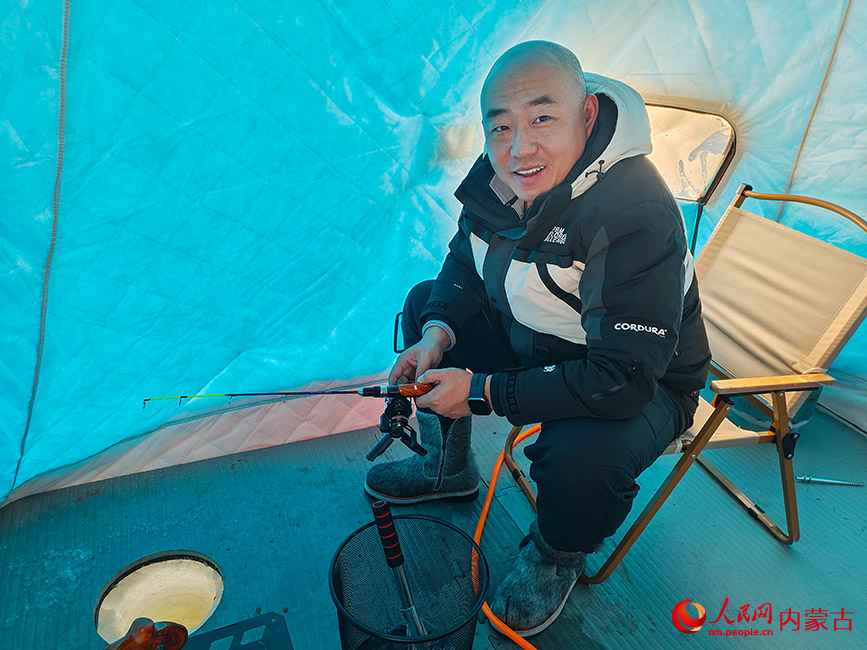 游客俯身尝试冰钓。实习生 刘迎雪摄