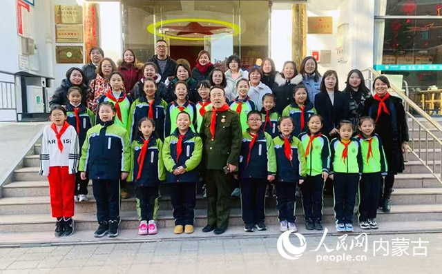 魏明深入学校进行爱国主题宣讲，并与学生们合影。受访人供图