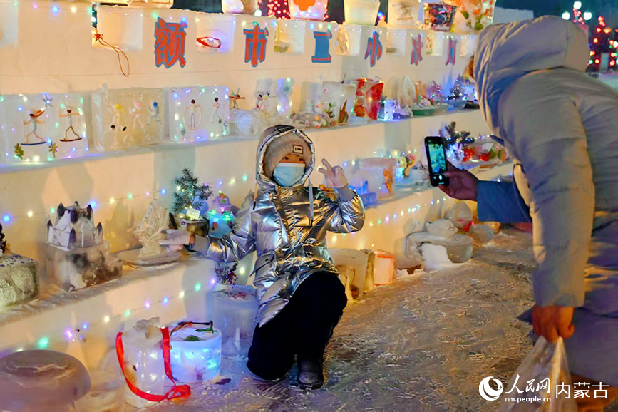 家長欣喜地為孩子與她親手制作的冰雕作品合影留念。實習生 劉迎雪攝