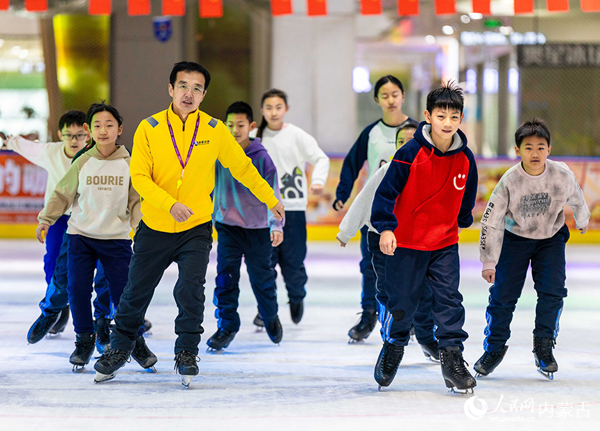 内蒙古呼和浩特市玉泉区小召小学学生在专业教练的带领下练习滑冰。丁根厚摄