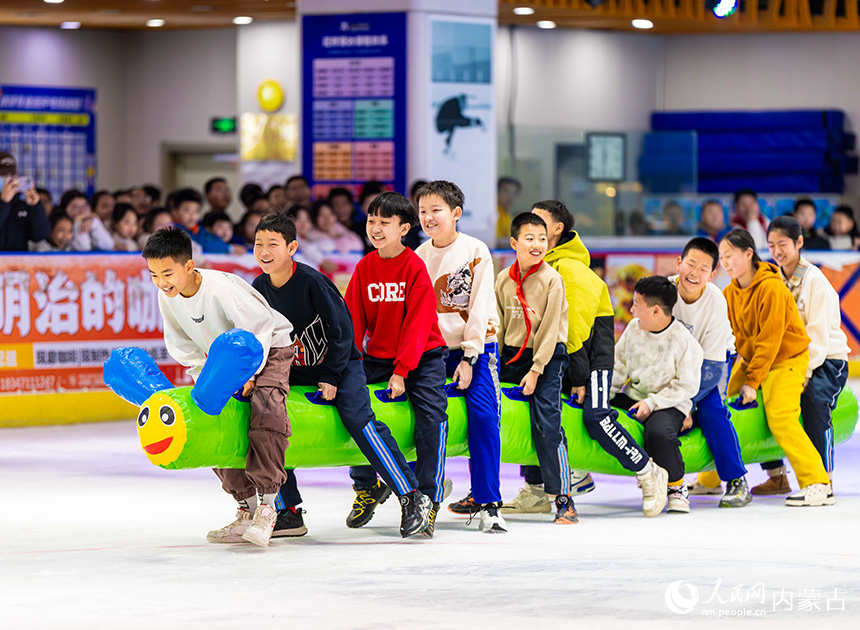 内蒙古呼和浩特市玉泉区小召小学学生在玩冰上毛毛虫趣味游戏。丁根厚摄