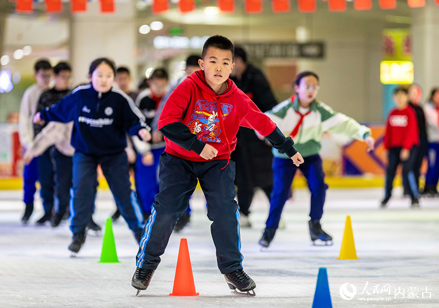 内蒙古呼和浩特市玉泉区小召小学学生在冰场练习滑冰基本功。丁根厚摄