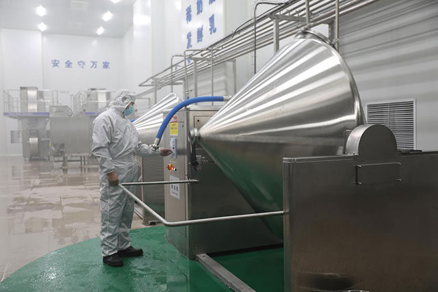在标准化生产车间内技术员正在操作甩油机。王苏日古嘎摄