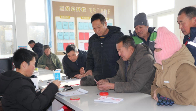 在茫汗苏木常海嘎查党群服务中心,村民额尔敦宝力稿(右二)领取了1000元医保缴费补贴。梅英摄