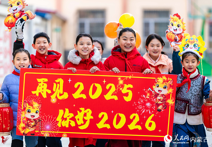 呼和浩特市玉泉區恆昌店巷小學學生手持“再見2025——你好2026”標語，喜迎新年的到來。丁根厚攝