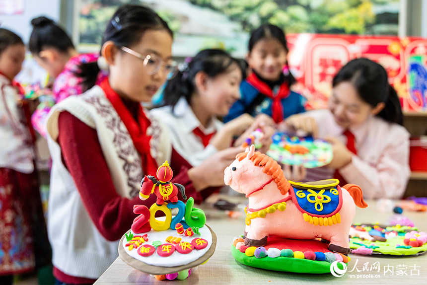 呼和浩特市玉泉区恒昌店巷小学学生在制作以生肖马为主题的彩泥作品。丁根厚摄