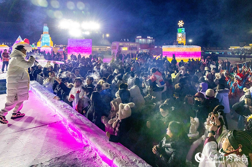 歌手在第五届呼和浩特欢乐冰雪节现场与游客互动。丁根厚摄