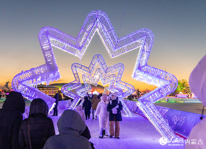 游客在第五届呼和浩特欢乐冰雪节园区游玩赏灯。丁根厚摄