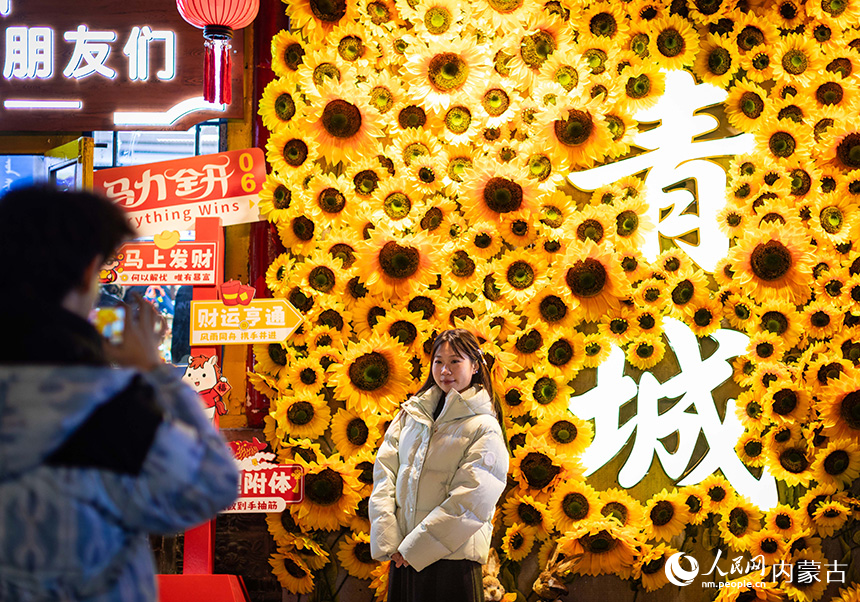 游客在呼和浩特市玉泉区塞上老街旅游休闲街区打卡留影。丁根厚摄
