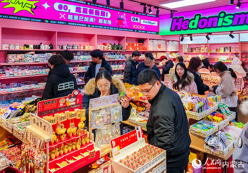 游客在呼和浩特市玉泉區塞上老街旅游休閑街區選購個性小商品。丁根厚攝