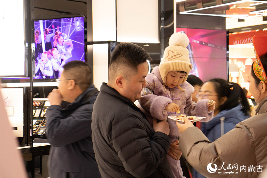 游客帶孩子品嘗額爾古納展區的列巴。實習生 張詩婕攝