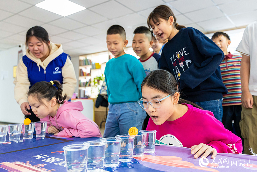 在呼和浩特市玉泉区秋实社区，集中托管的学生在玩趣味游戏。丁根厚摄