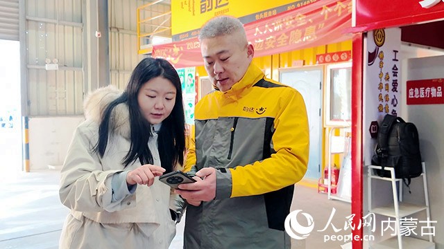 工作人員給梁峰（右）介紹如何用手機查詢社保信息。實習生 廖躍卿攝