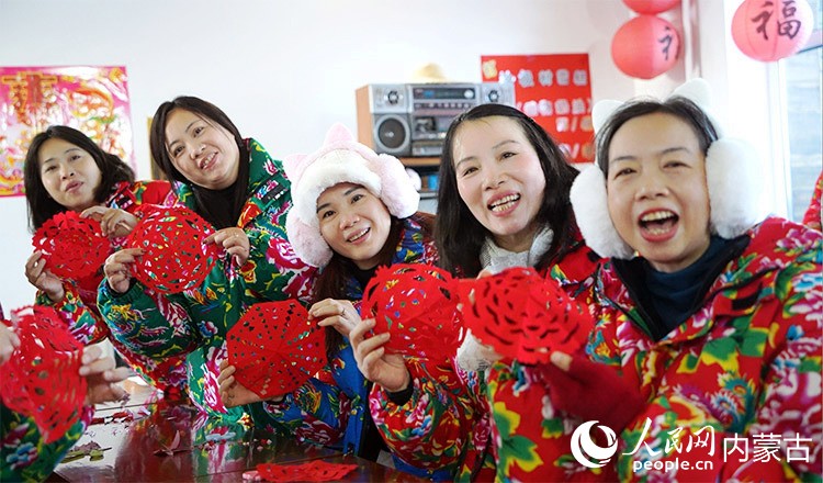 來自廣東虎門的游客體驗冷極村“剪窗花”制作項目，圖為游客向記者展示剪好的窗花。人民網記者 張力洋攝