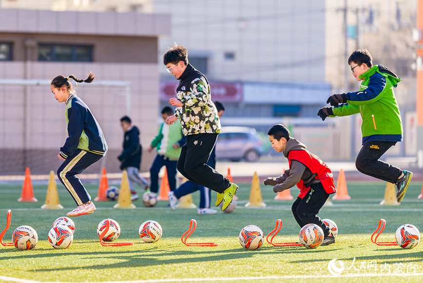 2月1日，呼和浩特市玉泉区南茶坊小学校园足球冬训活动现场，小球员们在绿茵场上进行体能训练。丁根厚摄