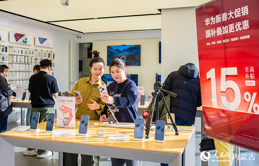 消费者在内蒙古呼和浩特市玉泉区七彩城一家品牌销售店内挑选手机。丁根厚摄