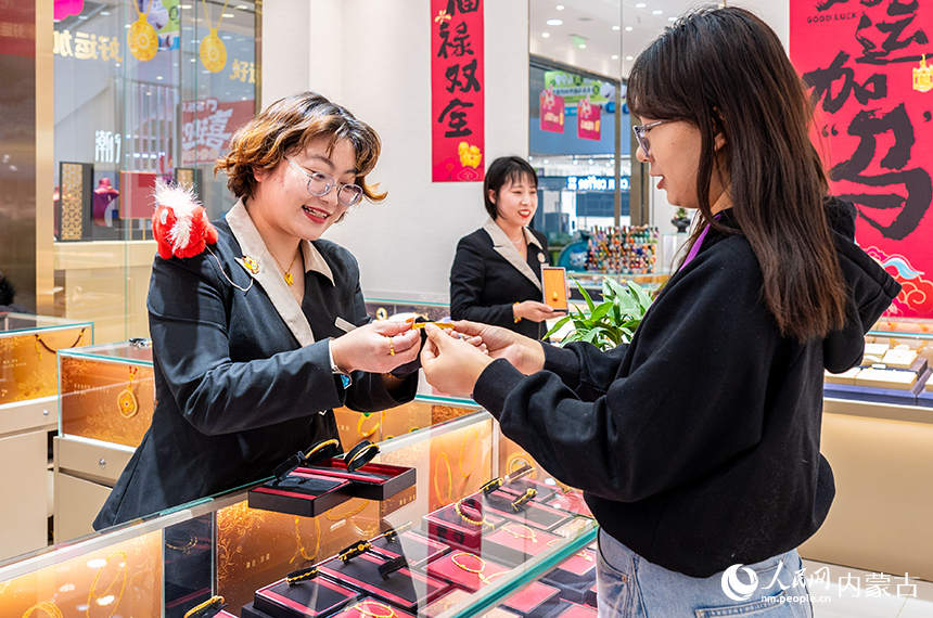 消费者在内蒙古呼和浩特市玉泉区七彩城一家金店内挑选首饰。丁根厚摄