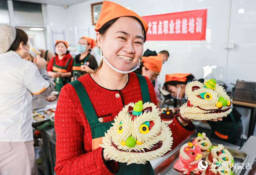 学员在呼和浩特市玉泉区一家培训学校展示制作好的醒狮花馍。丁根厚摄