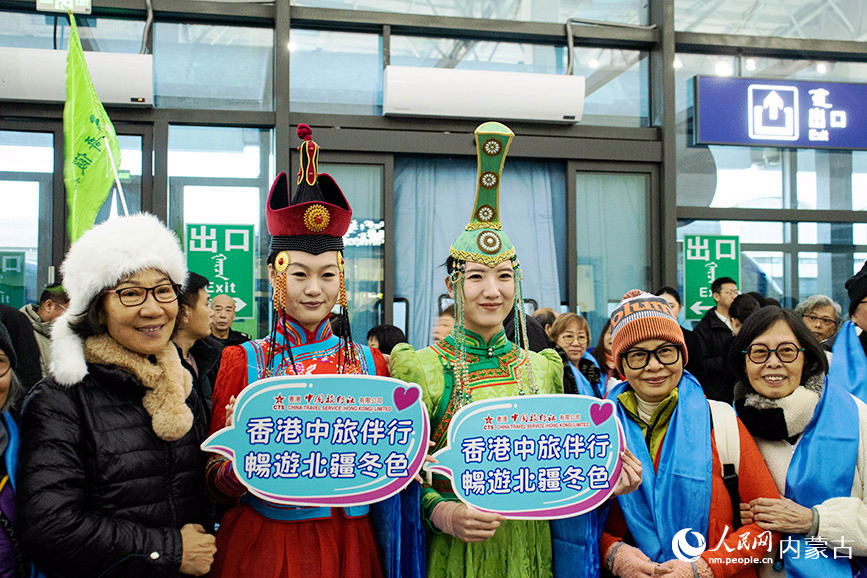 旅客與身著民族服飾的工作人員合影。實習生 張詩婕攝