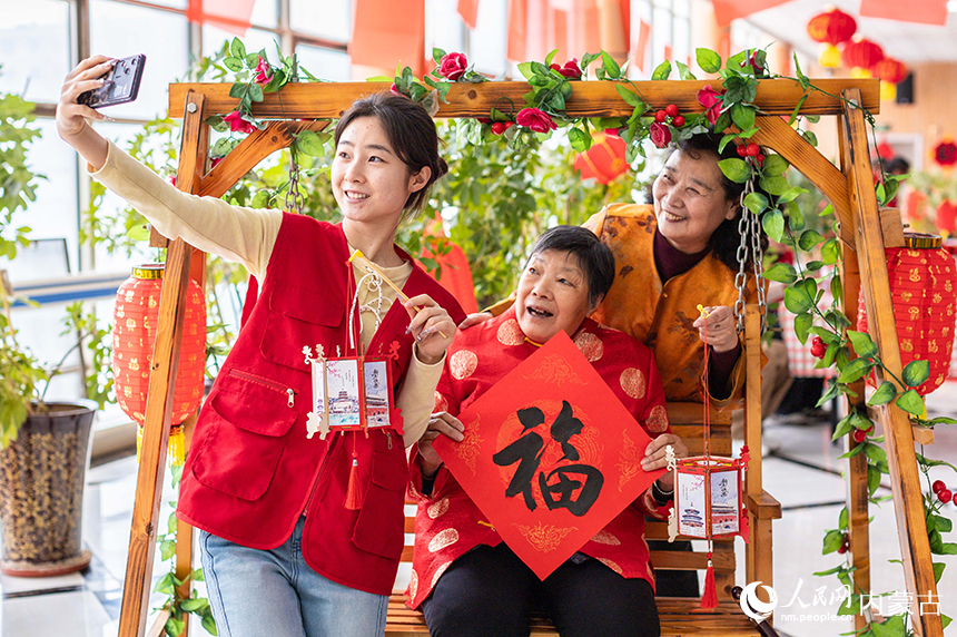 呼和浩特市玉泉区民政局的青年志愿者和老人们一起拍照留影。丁根厚摄