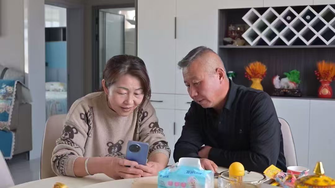 牧民劉尚榮、丁光梅夫婦與兒子視頻通話。