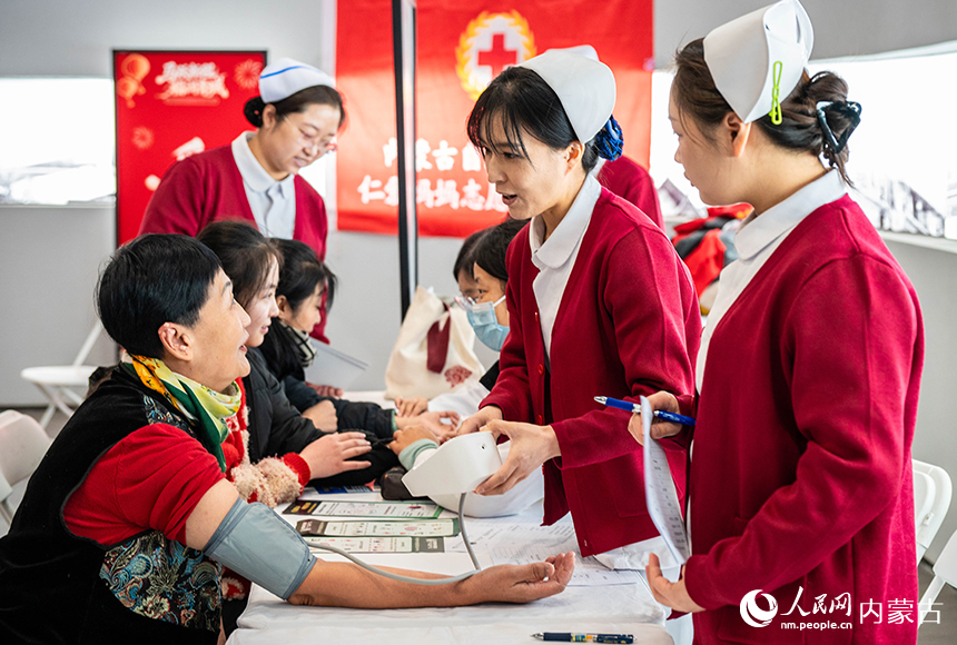 呼和浩特市“我们的节日·春节”主题活动现场，医护志愿者在为市民量血压。丁根厚摄