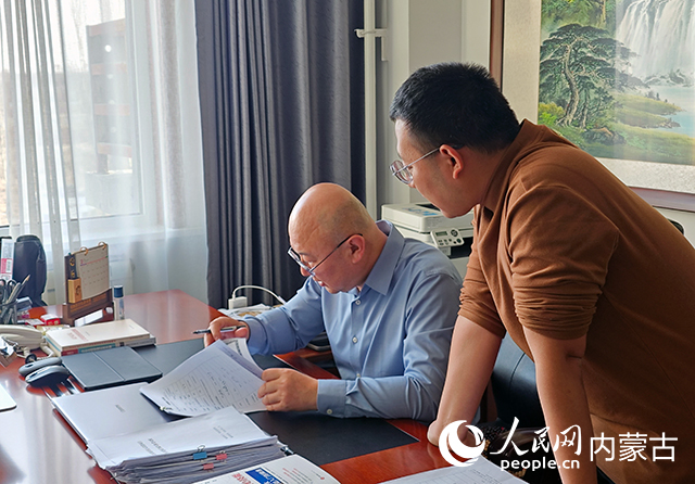 郭小峰正在和同事溝通合同簽署事宜。人民網記者 劉藝琳攝