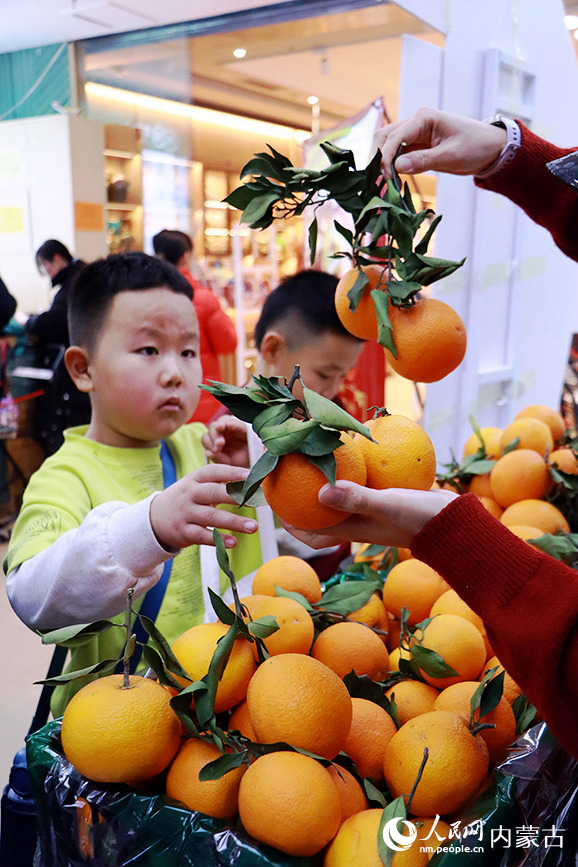 小朋友用闲置书换脐橙。实习生 牛子萌摄