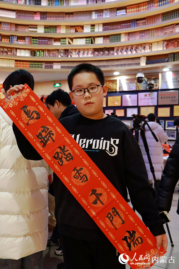 小朋友展示寫好的春聯。實習生 牛子萌攝