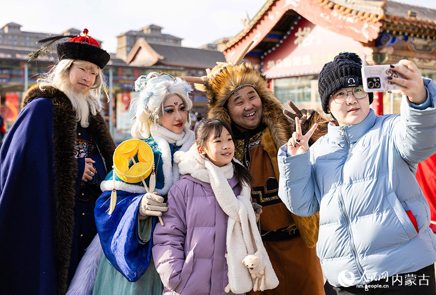 2月22日，呼和浩特新春文化廟會活動現場，市民與仙俠NPC巡游方陣的演員拍照留影。丁根厚攝