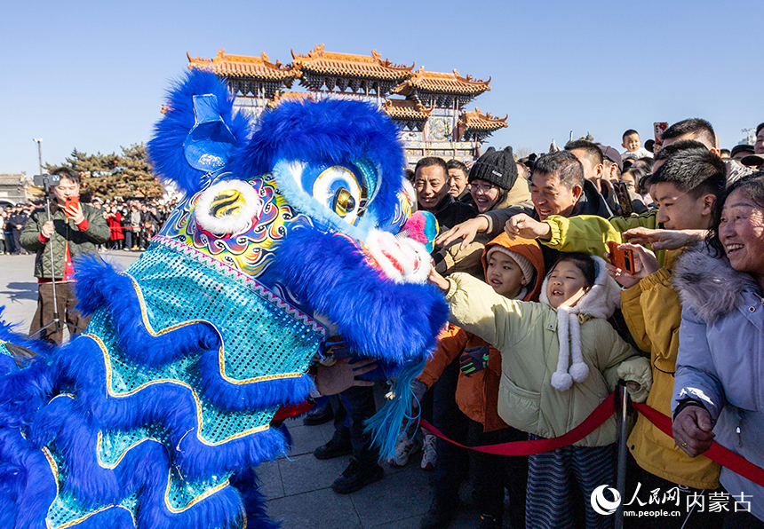 呼和浩特新春文化廟會“游八仙”主題活動現場，表演梅花樁醒獅的演員與游人互動。丁根厚攝