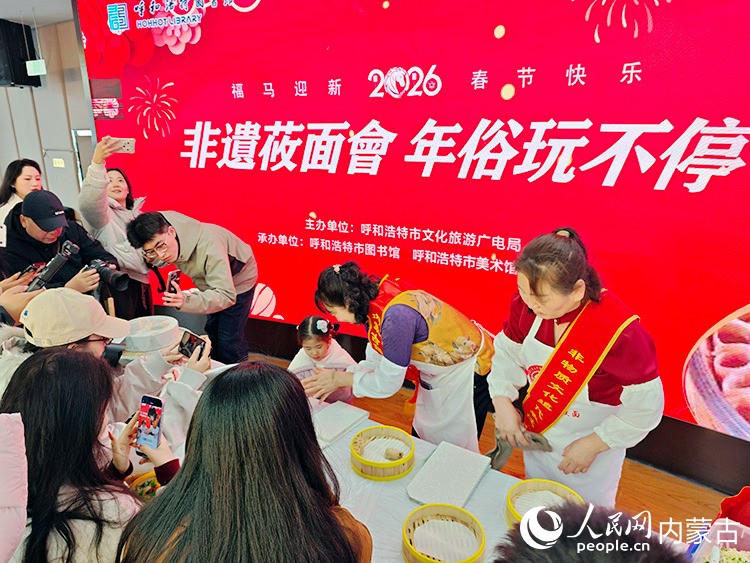 “图书馆莜面会·年俗玩不停”品味传统手工莜面非遗体验活动现场，莜面制作技艺项目非遗传承人正在教市民做莜面。人民网记者 刘艺琳摄