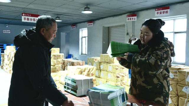 库伦旗新华书店工作人员按学校、年级、科目精准分拣教材教辅。梅英摄