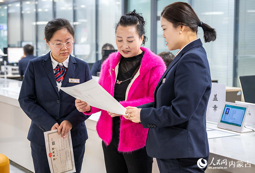 工作人員在呼和浩特市玉泉區政務服務中心將制辦好的營業執照交給商戶。丁根厚攝