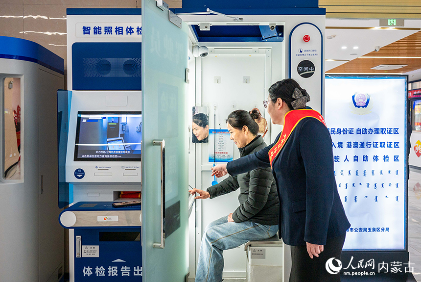 工作人員（右）在呼和浩特市玉泉區政務服務中心“24小時政務服務自助超市”內指導群眾辦理業務。丁根厚攝