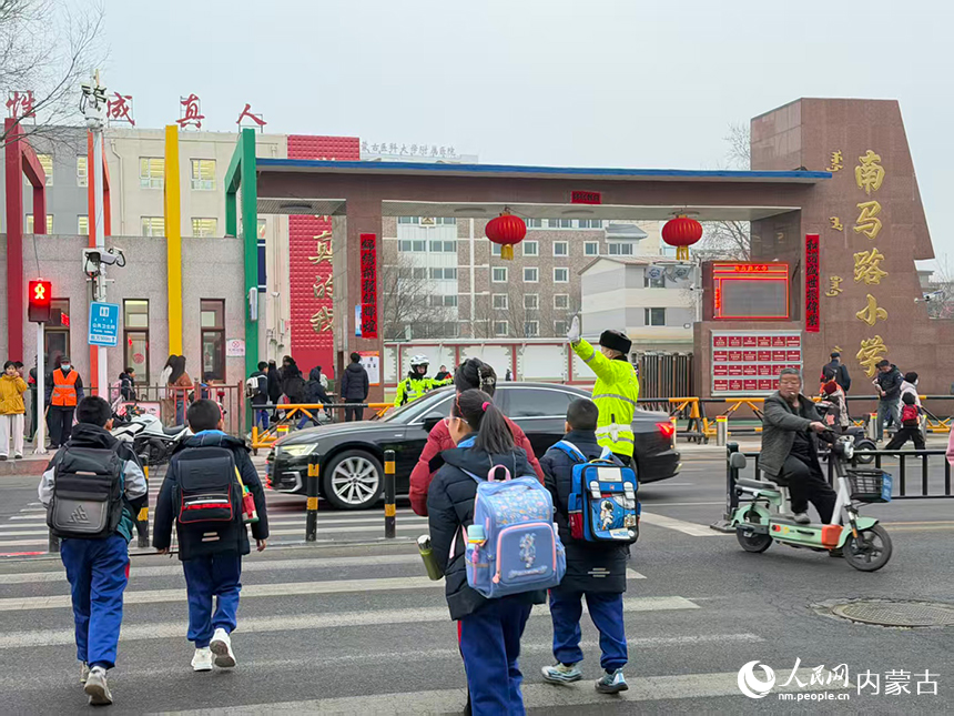 民警在校园周边关键路口、路段实时疏导车流。呼和浩特市公安局供图