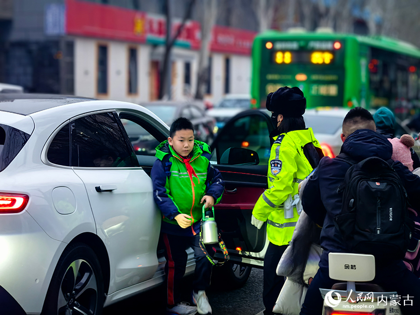 民警在校园周边关键路口、路段实时疏导车流。呼和浩特市公安局供图