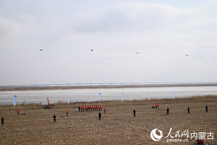 4架大型無人機在地面引導下投擲特種破冰彈。人民網記者 劉藝琳攝