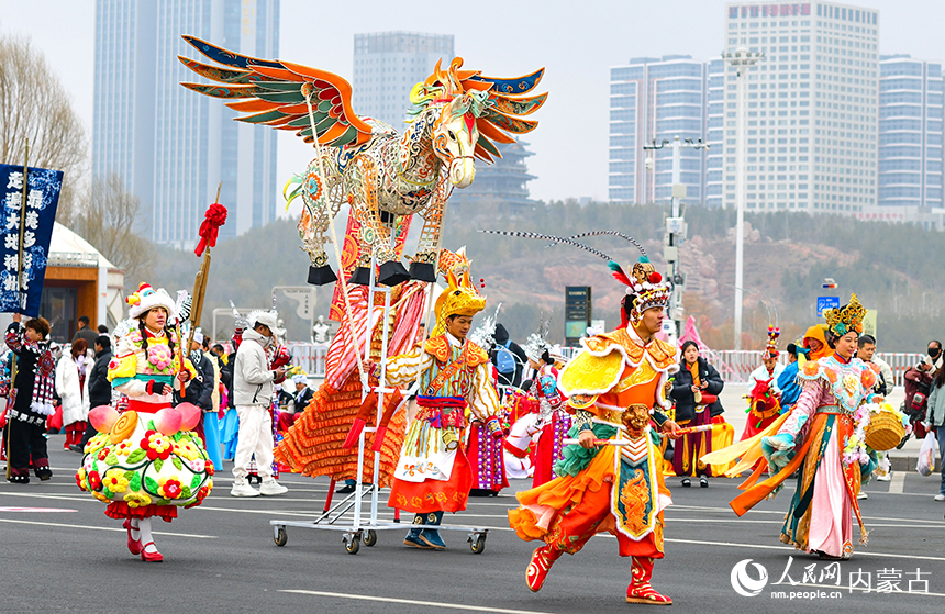 演员在鄂尔多斯市2026年群众迎春年俗巡游活动中表演新编社火节目神驹献瑞。王正摄