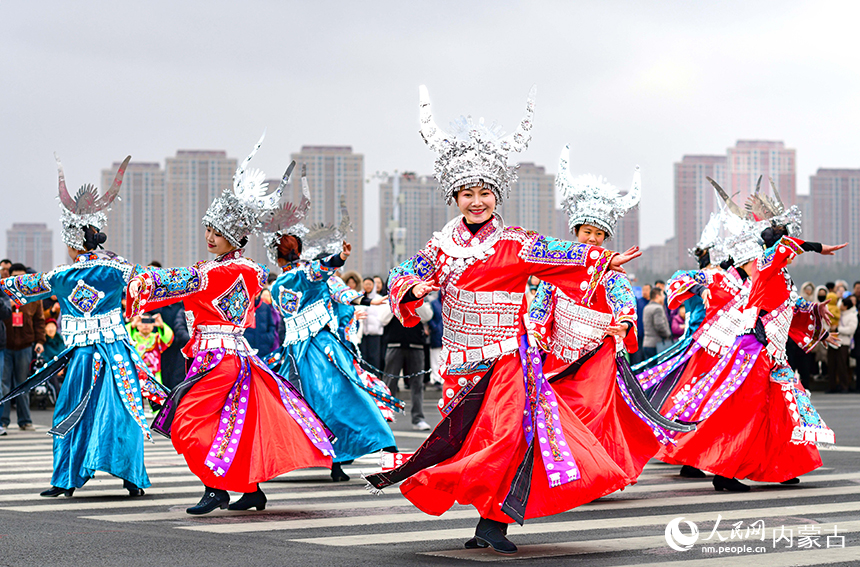 演员在鄂尔多斯市2026年群众迎春年俗巡游活动中表演苗族踩鼓舞。王正摄